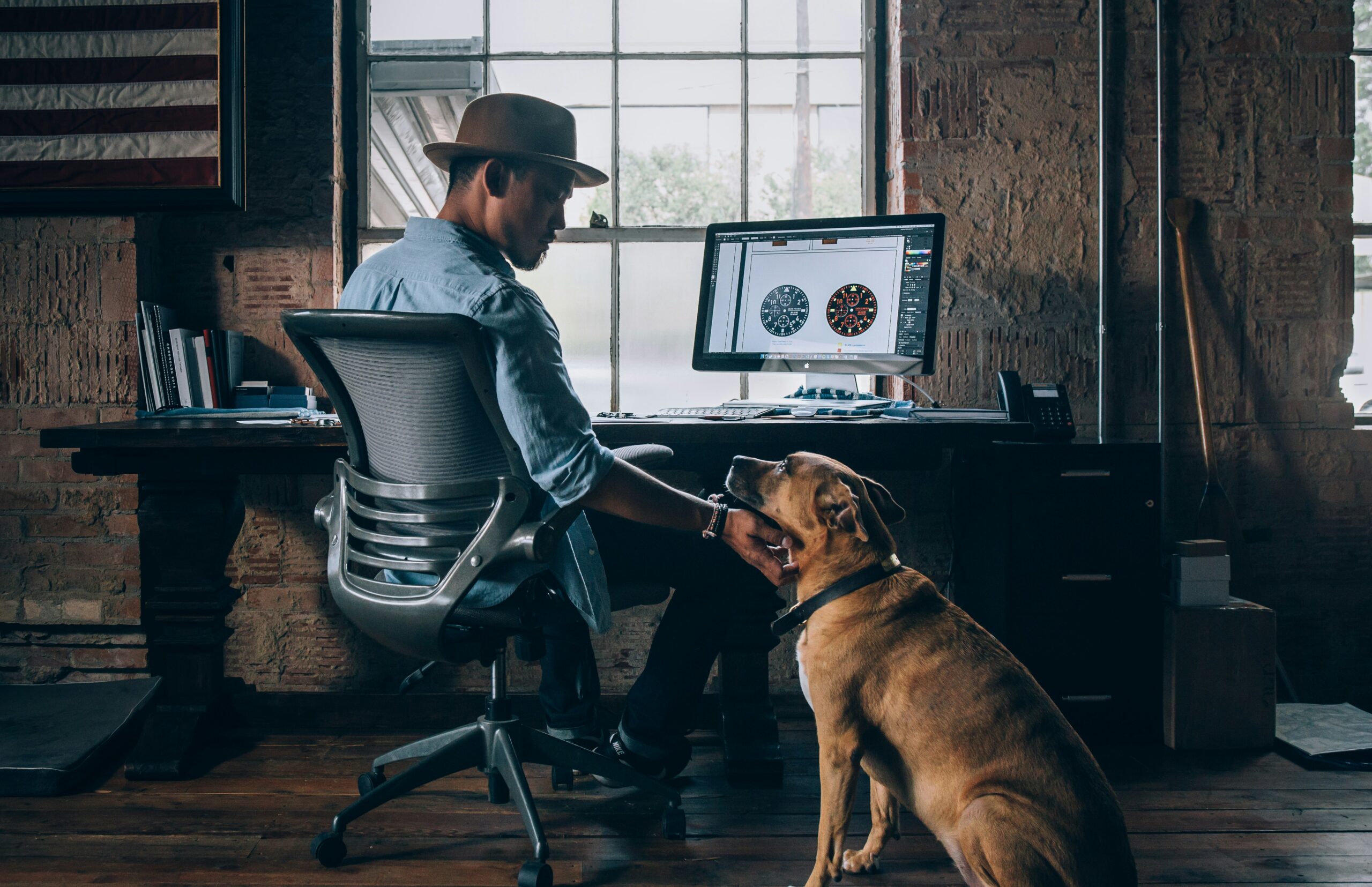 man sitting on rolling chair holding dog